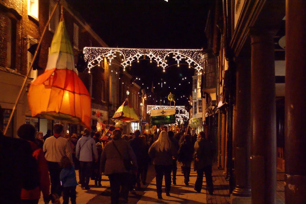 Lanterns carried along Winchester High Street under the Christmas lights